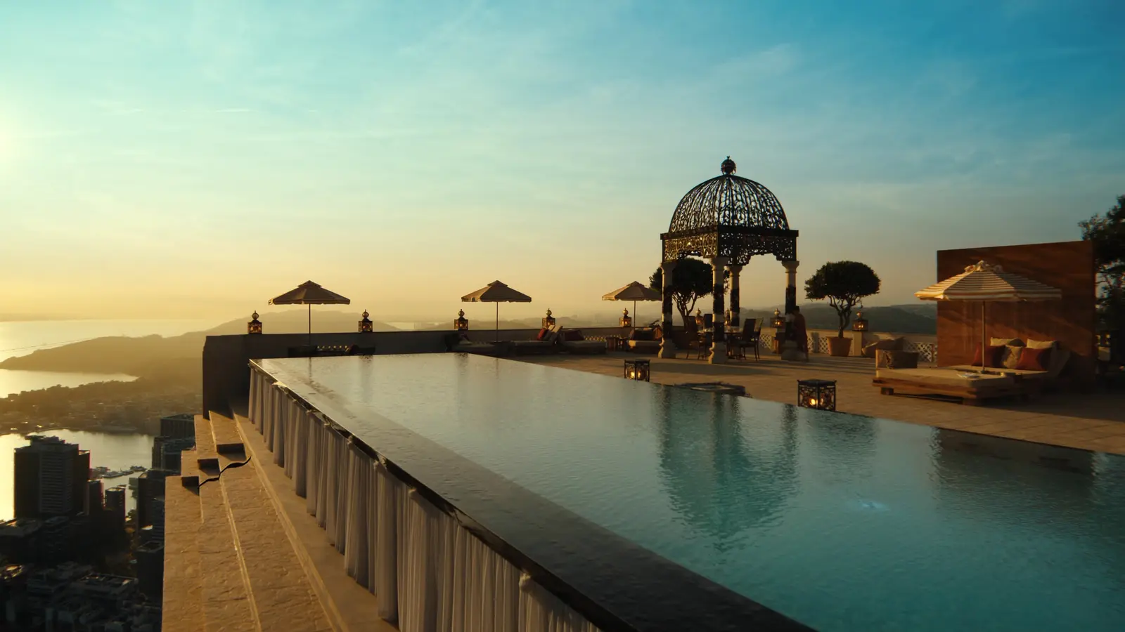 An elegant luxury hotel terrace overlooking a city skyline at golden hour